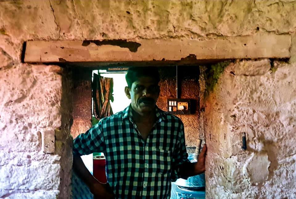 Man in a checked shirt standing in the doorway of a small teashop