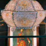 Ornate silver filigree casket in a display case