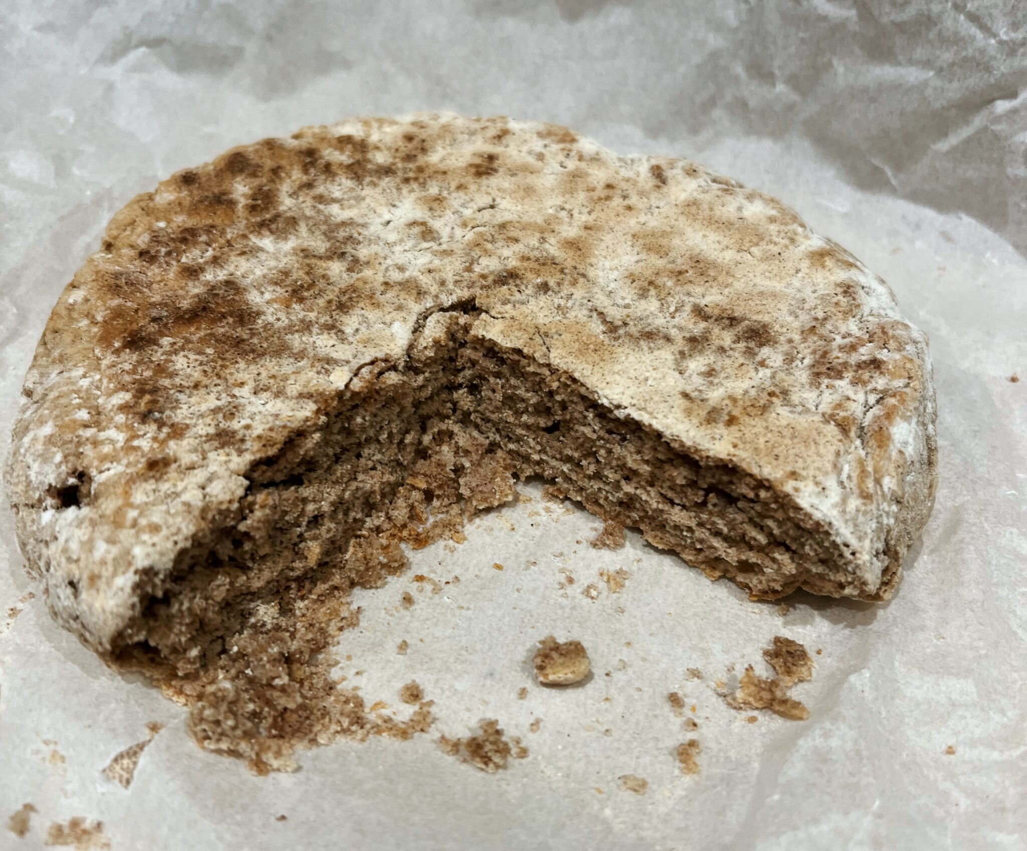 Round bere bannock flatbread broken open on paper